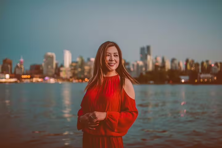Woman in red dress with Toronto skyline at dusk during a private tour with personal travel photographer