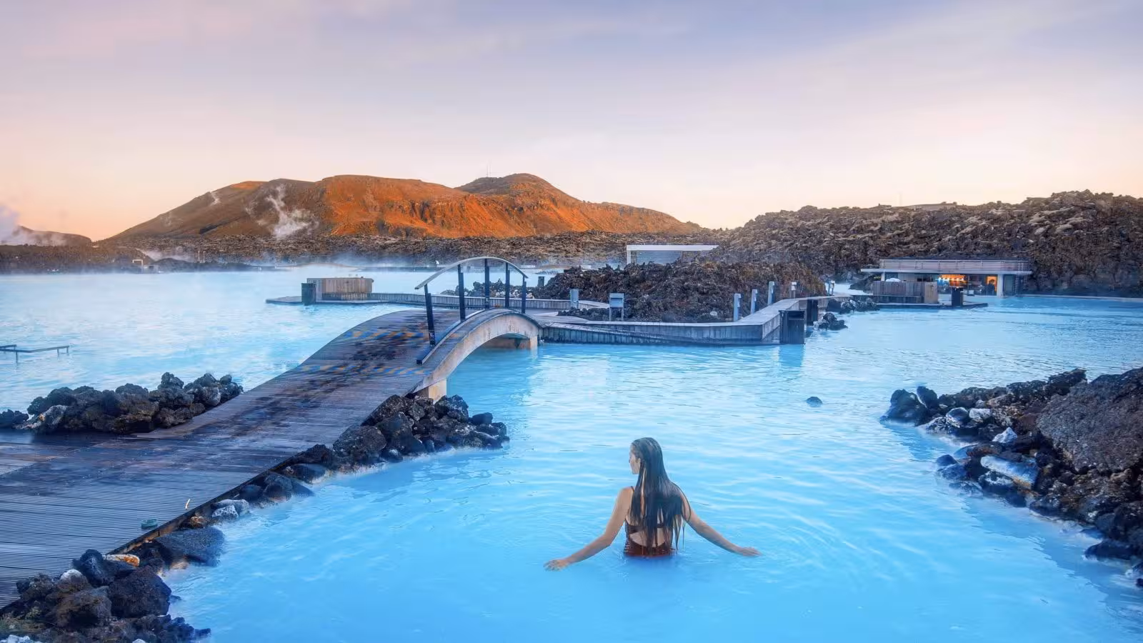 Woman relaxing in the Blue Lagoon geothermal spa, a popular Reykjavik to Blue Lagoon transfer tour stop