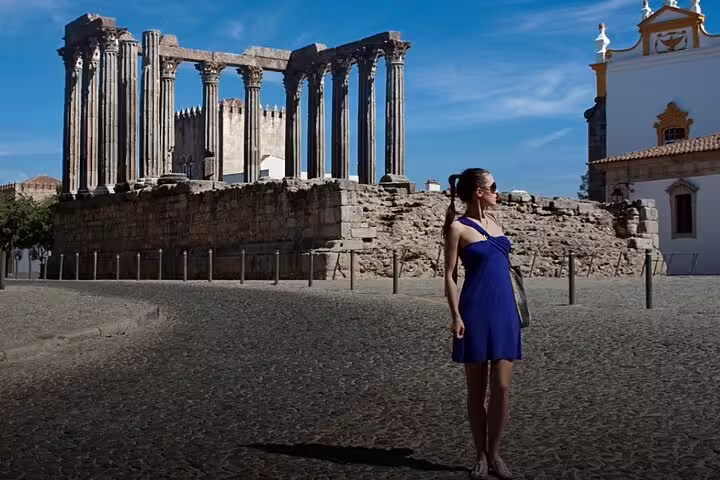 Woman exploring the Roman Temple of Évora on a sunny day during a private full-day wine tour from Lisbon in Alentejo.