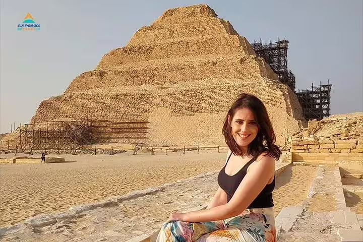 Woman seated by Saqqara Step Pyramid ruins, Egypt, on guided Sakkara and Memphis archaeological tour