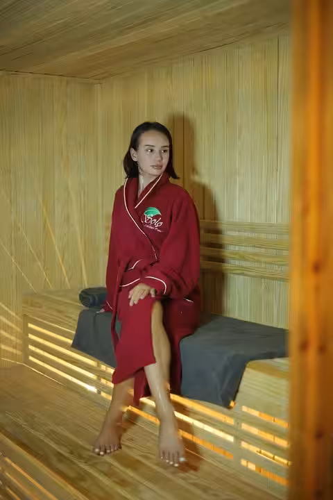 Woman seated in wooden sauna before Turkish hammam scrub and full-body massage, Sharm El Sheikh spa package