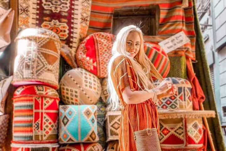 Woman shopping colorful handmade textiles in the bazaar, a highlight of the National Museum to Citadel tour