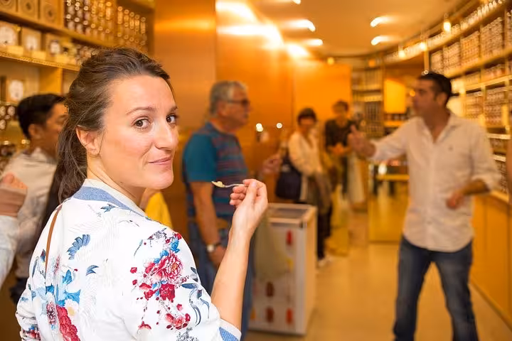 A woman sampling gourmet food in a Parisian shop during a private tour, showcasing French culinary expertise.