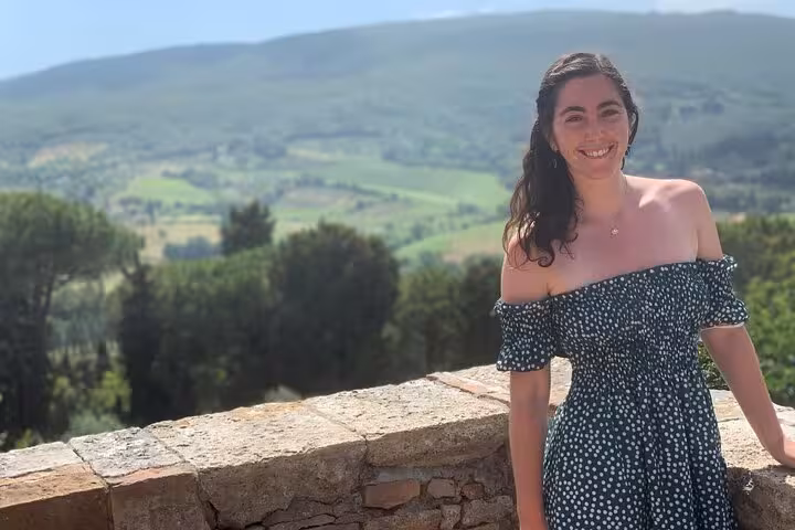 Woman enjoys scenic view of Tuscan countryside during Pisa, Siena, and San Gimignano tour from Florence.