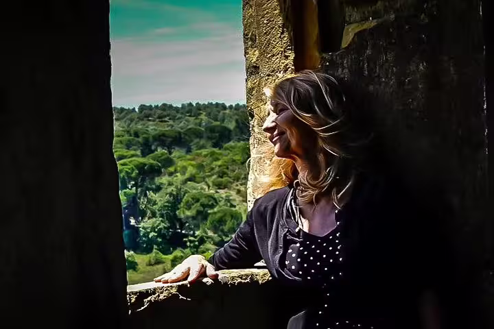 Woman enjoying a scenic view from a window at a historic site on the Óbidos, Nazaré, Alcobaça, Batalha, Fatima tour.