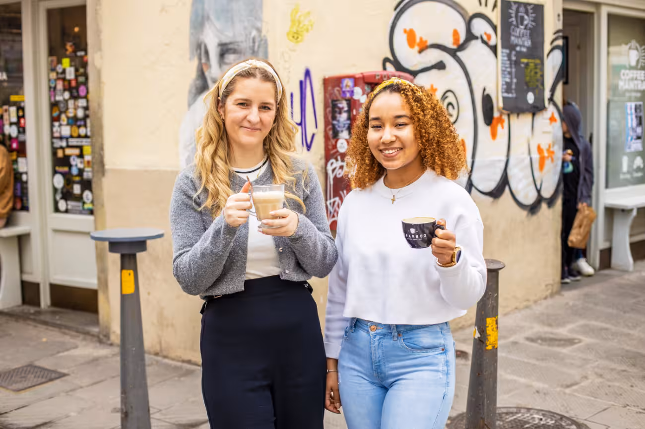Two women enjoying coffee outside a café in Florence during the Sant'Ambrogio food tour experience.