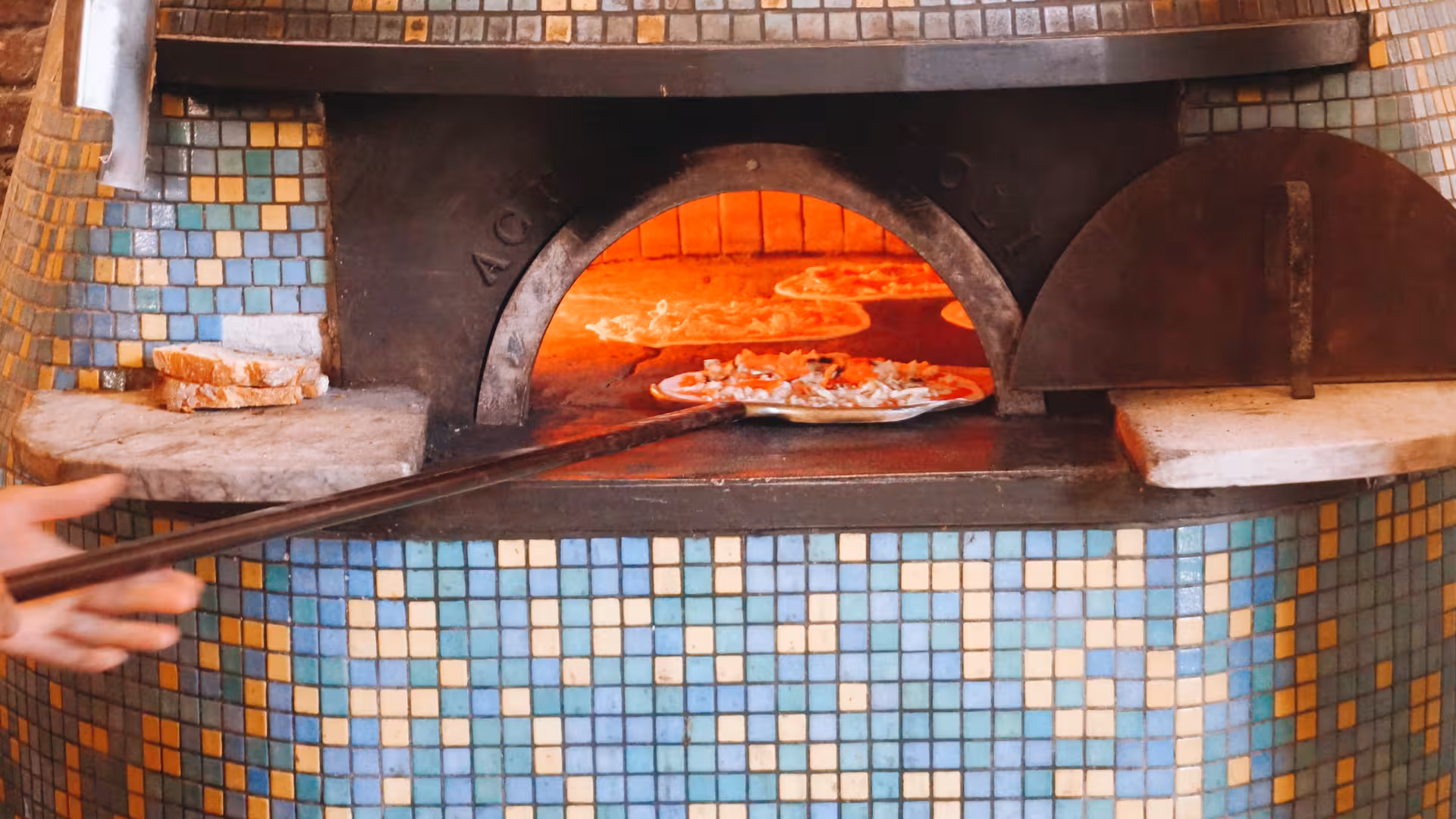 Wood-fired oven with pizzas baking during the Pizza Cooking Experience at Rome's Jazz Cafe.