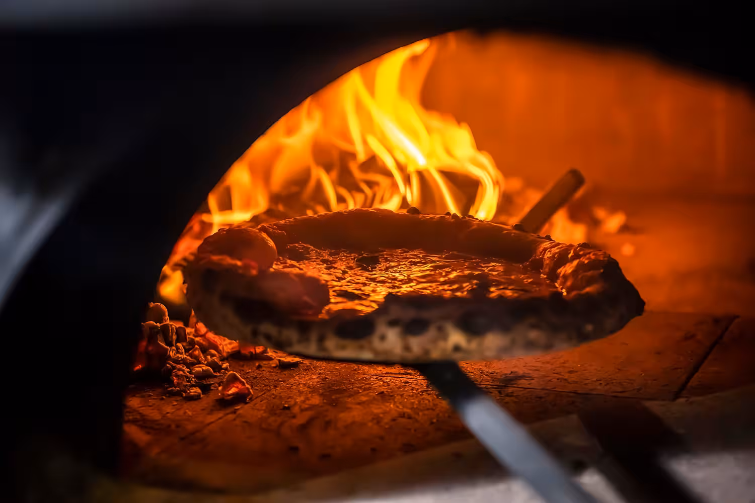 Wood-fired pizza baking in traditional oven during Florence cooking class with local chef.