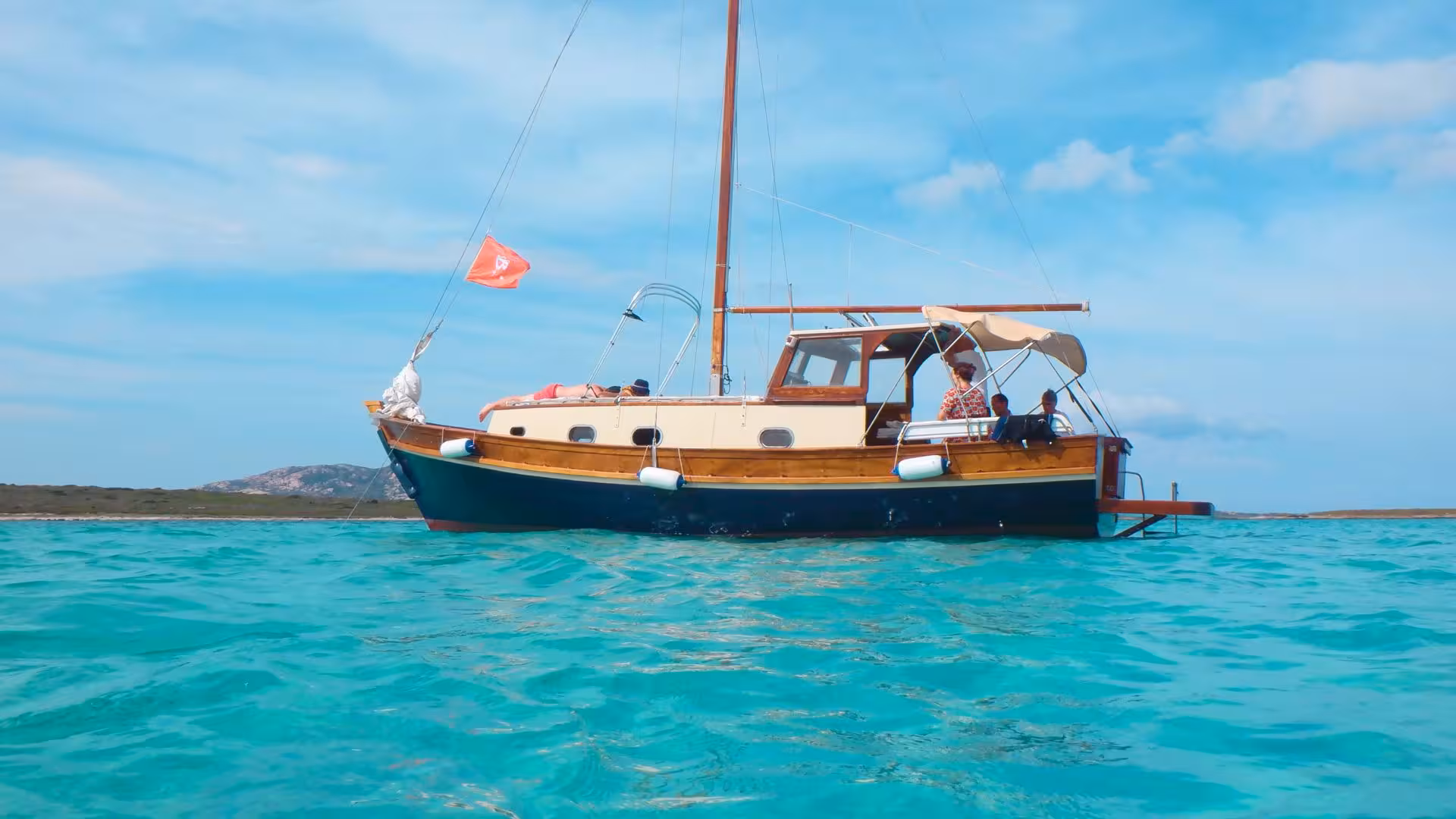 A classic wooden boat anchored in the serene turquoise waters of Stintino, perfect for an Asinara Island excursion.