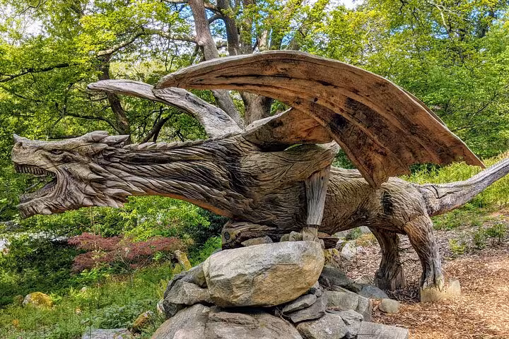 Wooden dragon sculpture in forest gardens, a quirky stop on the Snowdonia & 3 Castles Tour in Wales