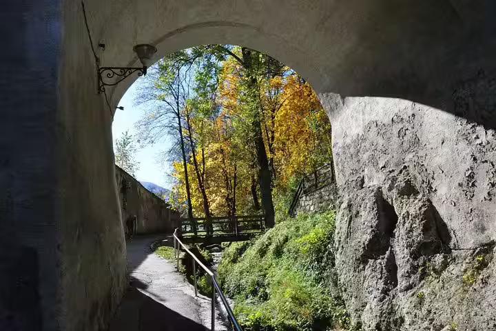 Stone arch tunnel framing autumn trees in Brasov Old Town walking tour
