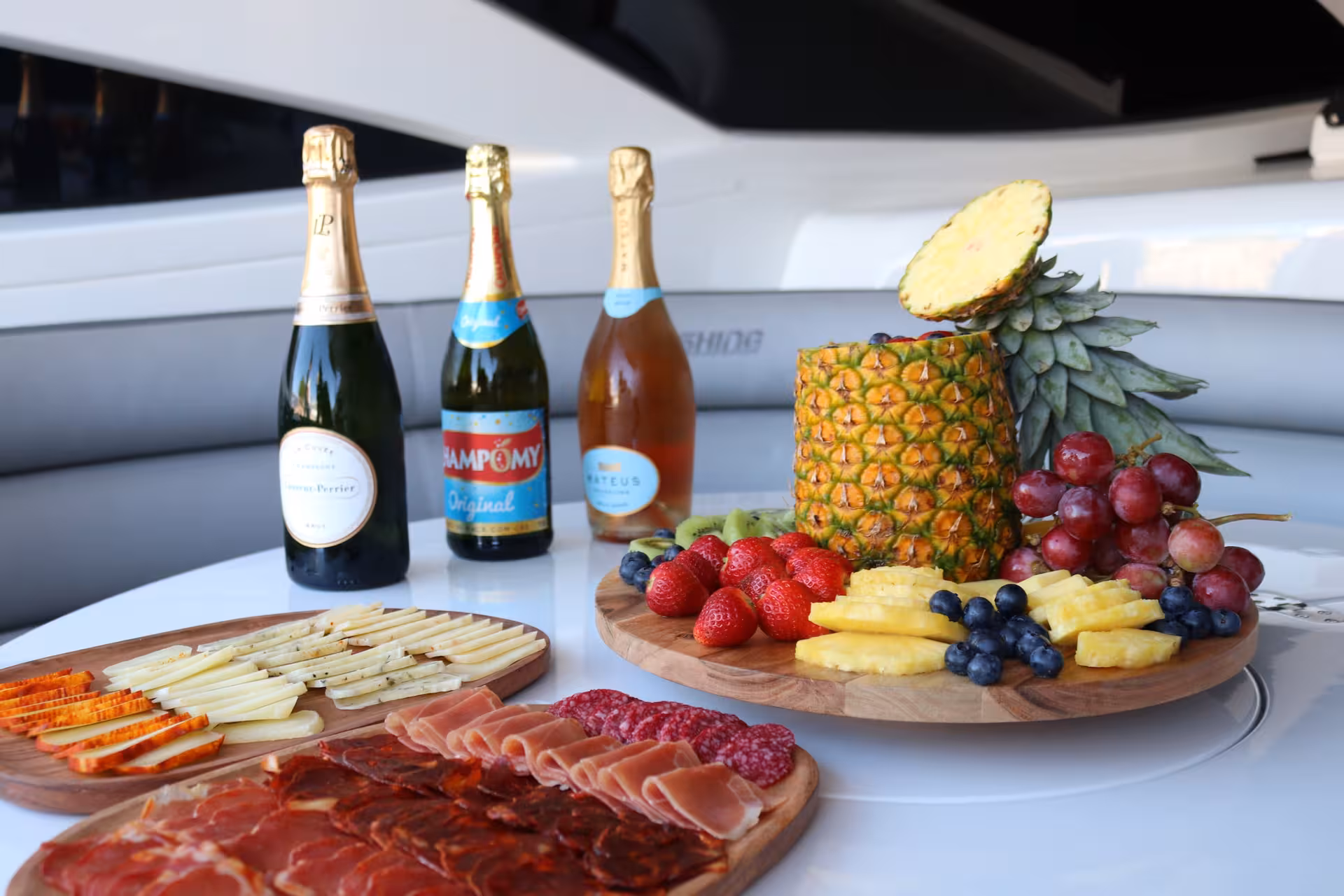 Gourmet fruit, cheese and charcuterie platters with champagne on deck of XCLUSIVE III Private Luxury Yacht in Dubai Marina