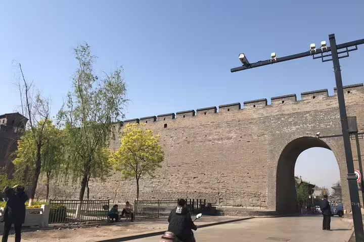 Historic city wall in Xian, showcasing ancient architecture on a sunny day during a Beijing to Pingyao bullet train tour.