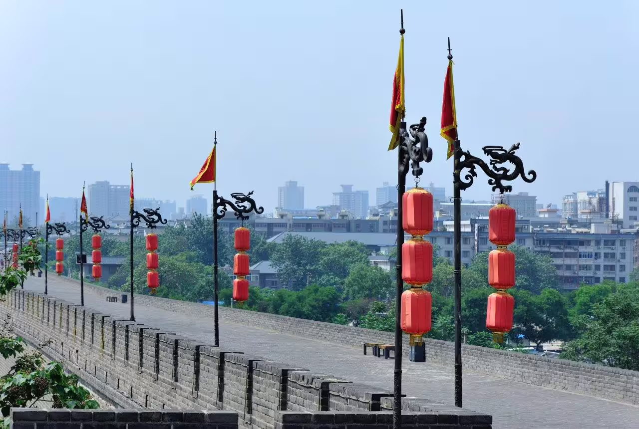 View of Xi'an City Wall adorned with red lanterns, showcasing ancient architecture and modern skyline.