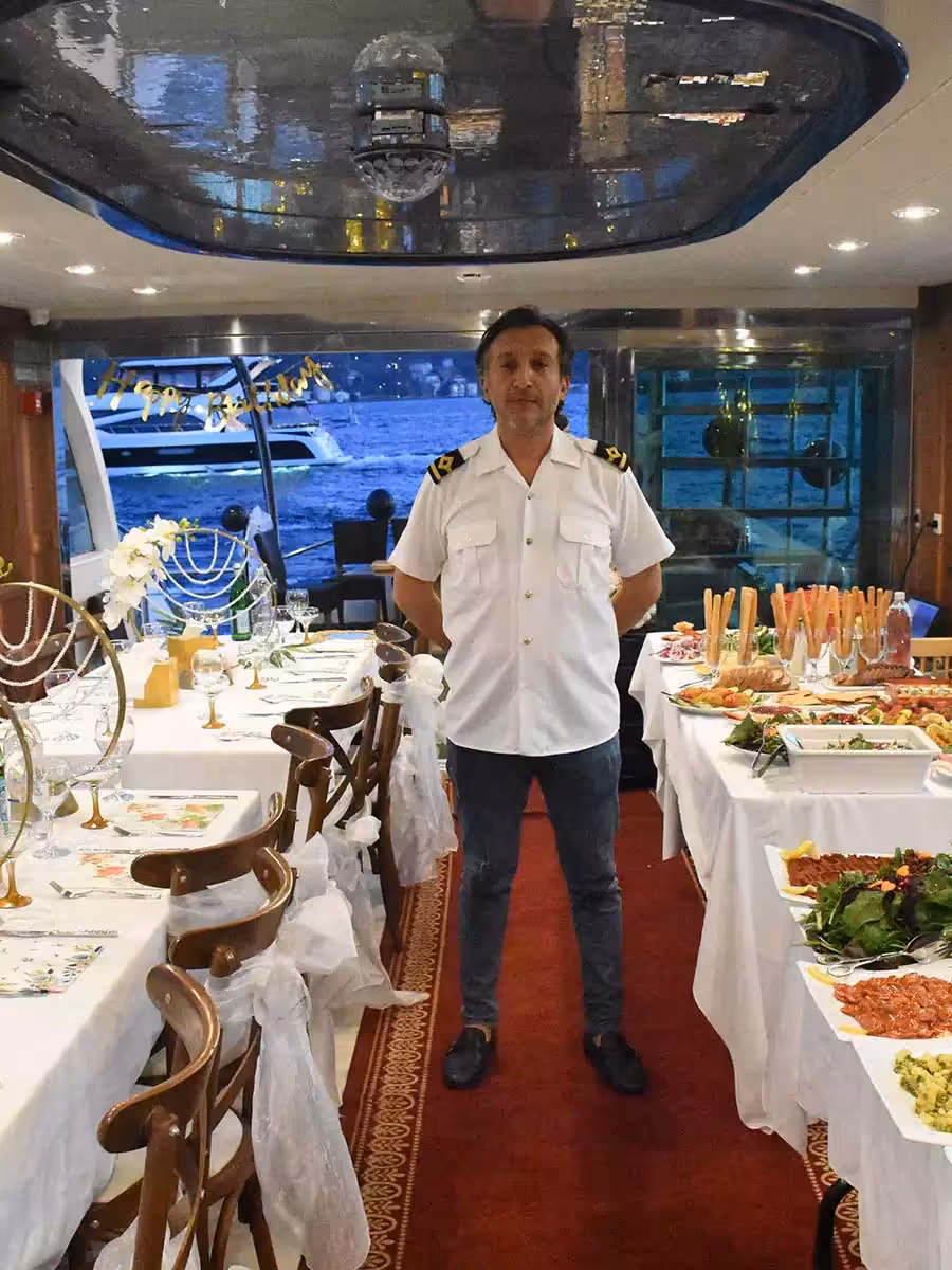 Yacht birthday party dining room with captain and buffet catering, decorated tables for a private cruise