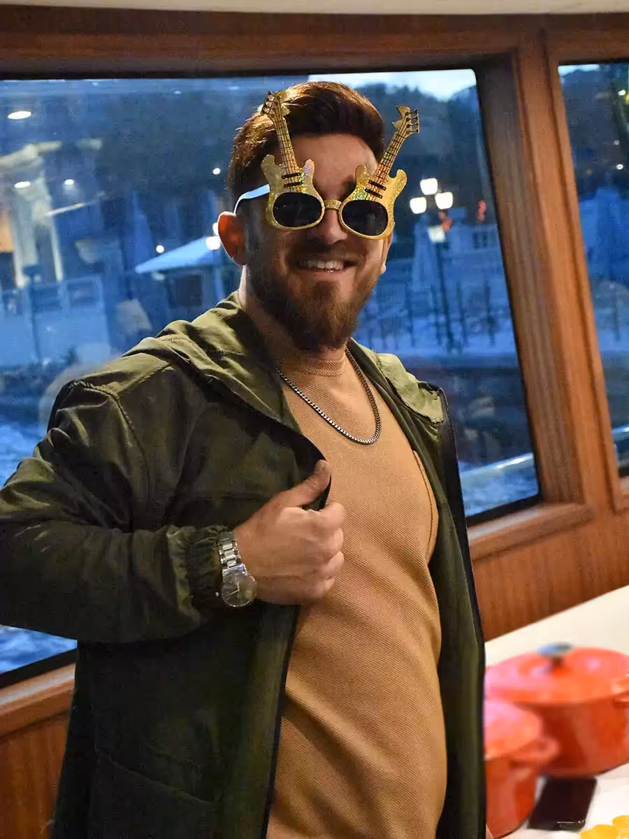 Guest wearing fun guitar sunglasses onboard, capturing the vibe of a yacht birthday party cruise celebration