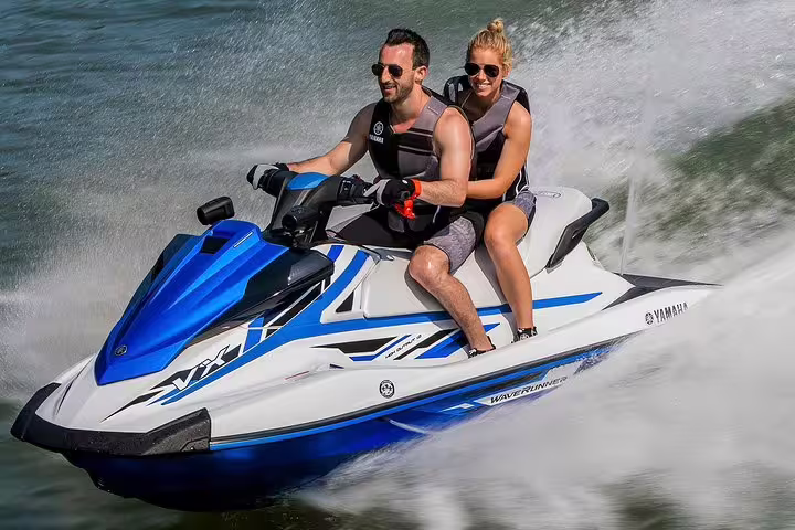Two riders on a Yamaha jet ski speeding on Ibiza waters during the San Antonio to Es Vedrá guided excursion