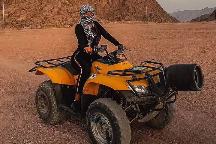 Woman on yellow quad bike in Sinai desert, private ATV safari adventure tour from Sharm El Sheikh Egypt
