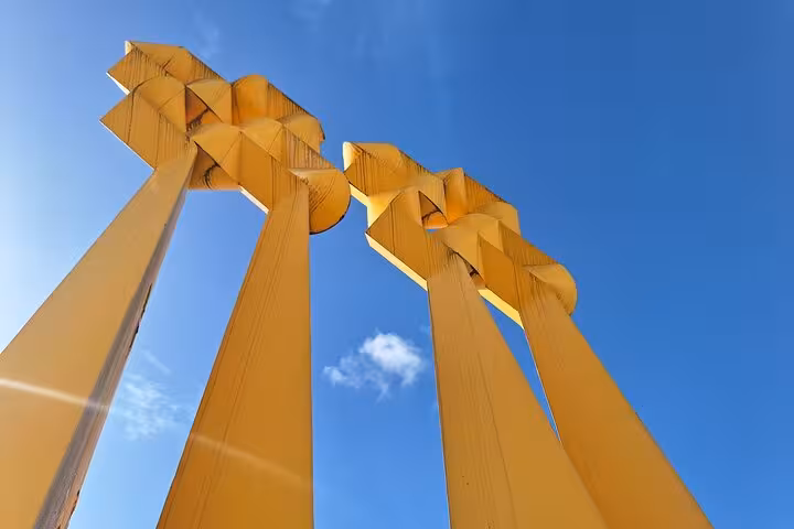 Unique yellow sculpture against a vivid blue sky, a modern landmark on the Cudillero, Aviles, and Cabo Peñas tour.