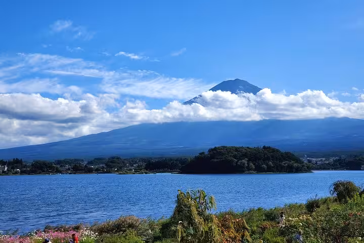 Scenic view of Mt. Fuji with clouds over a tranquil lake, perfect for a Yokohama Port to Mt. Fuji guided tour.
