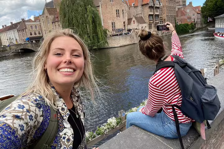 Friends taking photos by a canal during the Ypres e-scavenger hunt, self-guided city exploration tour