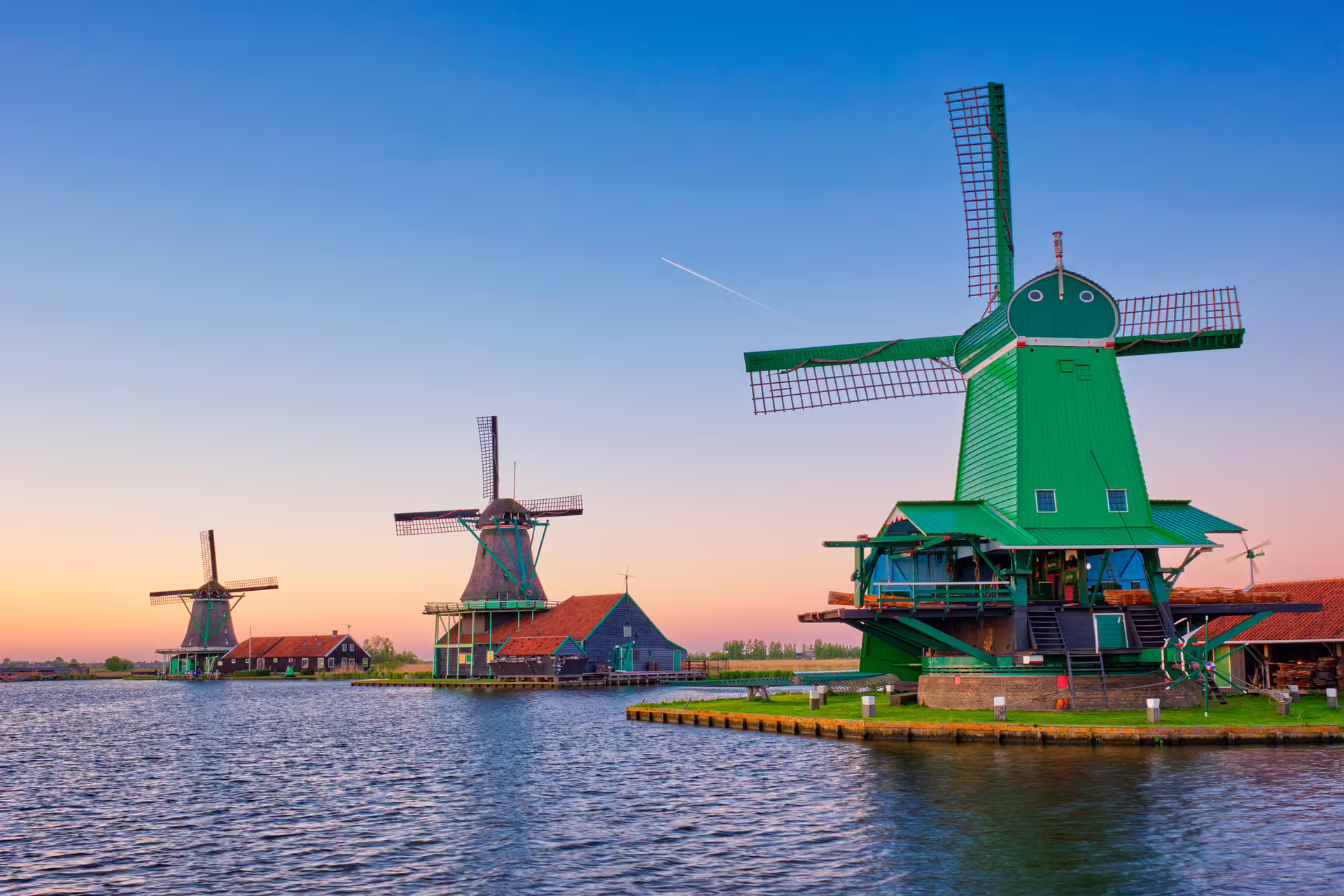 Green windmill on Zaanse Schans waterfront, highlight stop on 1-day walking tour with 7-language audioguide