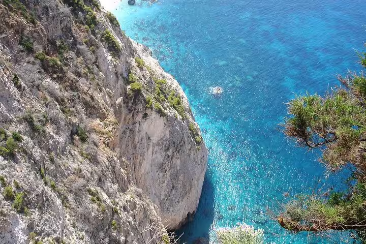 Dramatic limestone cliff above crystal-clear Ionian Sea on Southern Zakynthos half-day beaches scenic view tour