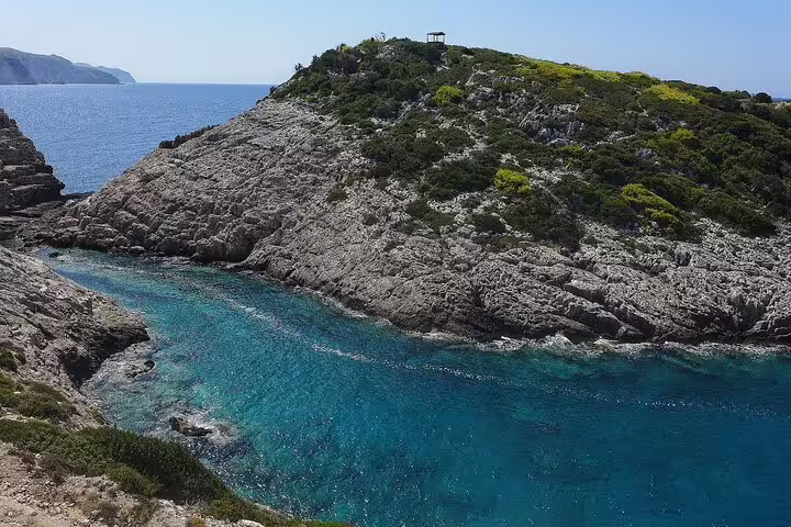 Secluded Zakynthos blue-water bay with rugged rocks, featured on Southern Zakynthos half-day beaches scenic view tour