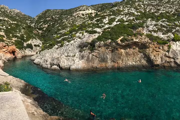 Swimmers in crystal-clear turquoise cove on southern Zakynthos half-day beaches and scenic view tour