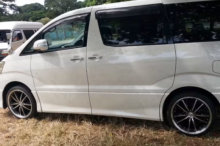 Side view of a spacious white minivan ready for private airport transfers to Nungwi Hotels in Zanzibar.