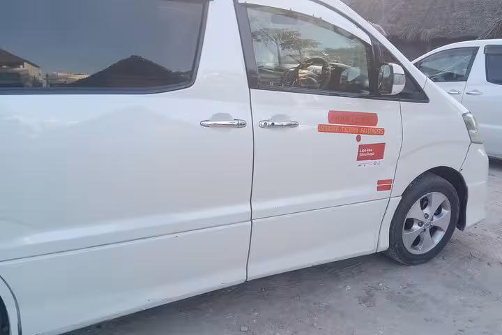 Close-up of a white private transfer van with company logo, offering reliable Zanzibar Airport to hotel service.