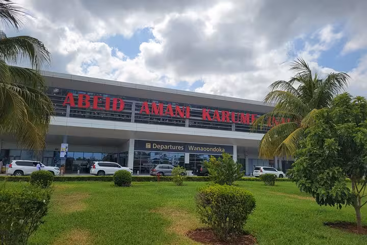 Abeid Amani Karume Airport departures with lush greenery, starting point for East Coast hotel transfers in Zanzibar.
