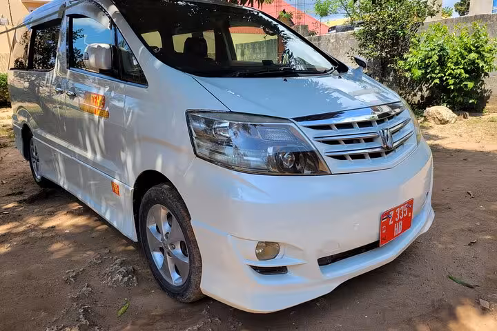 Front view of a white minivan used for private airport transfers in Zanzibar to East Coast hotels.