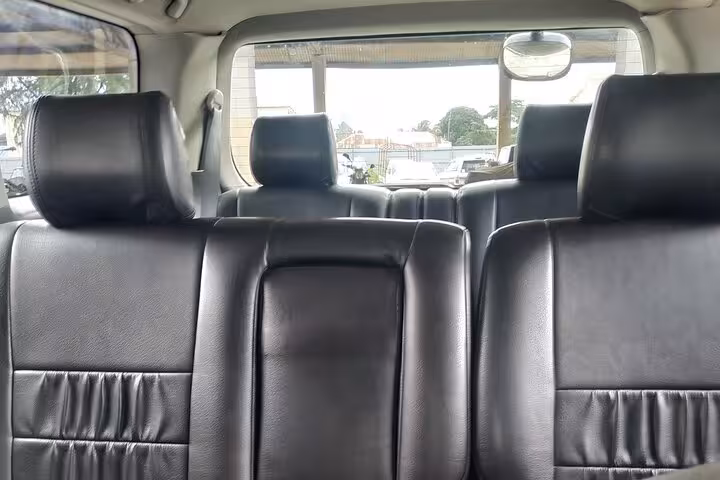 Spacious black leather interior of Zanzibar airport transfer shuttle, offering comfort and style for island travel.