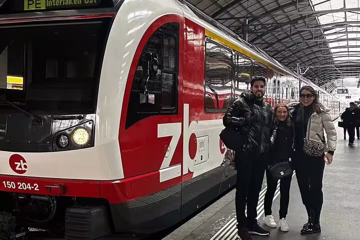 Travelers pose beside the zb panoramic train, ready for an exclusive journey through the heart of Swiss landscapes.