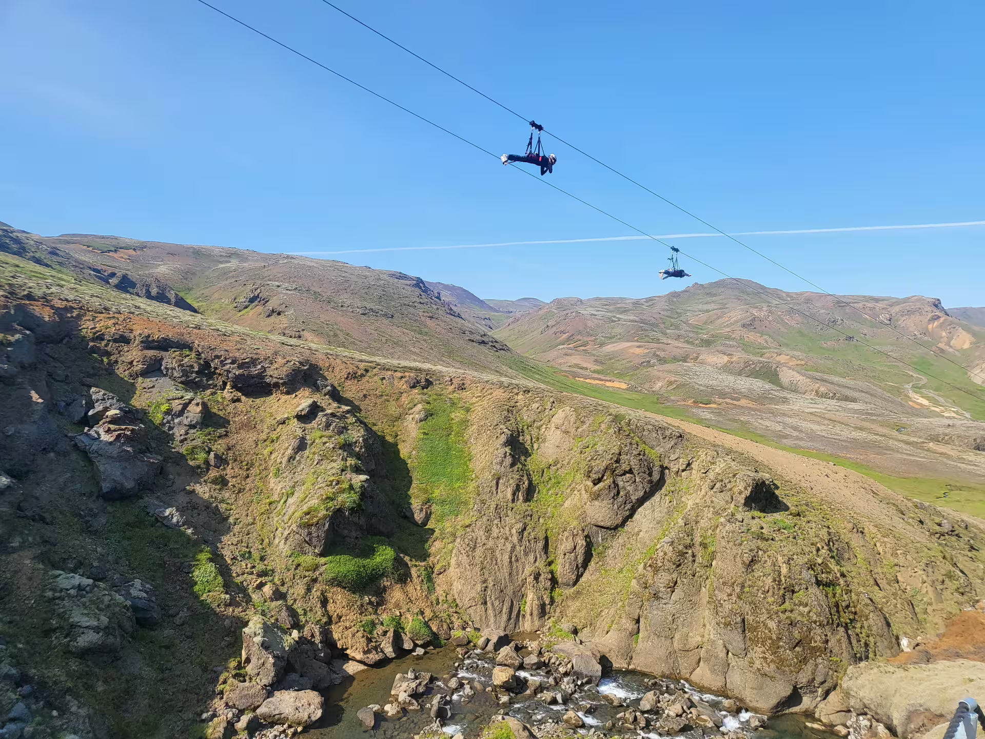Adventurers zipline over scenic canyon landscape, experiencing thrilling heights and breathtaking views on the Conventional Ride tour.