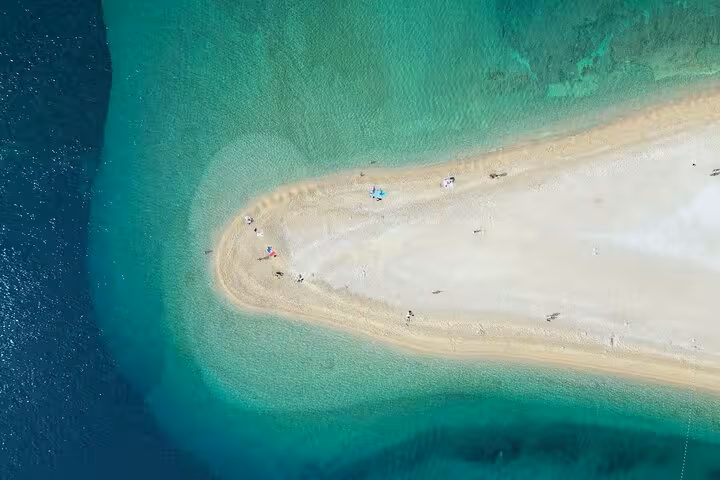 Drone shot of Zlatni Rat sandbar and clear Adriatic water, a highlight stop on Hvar and Paklinski Islands tour