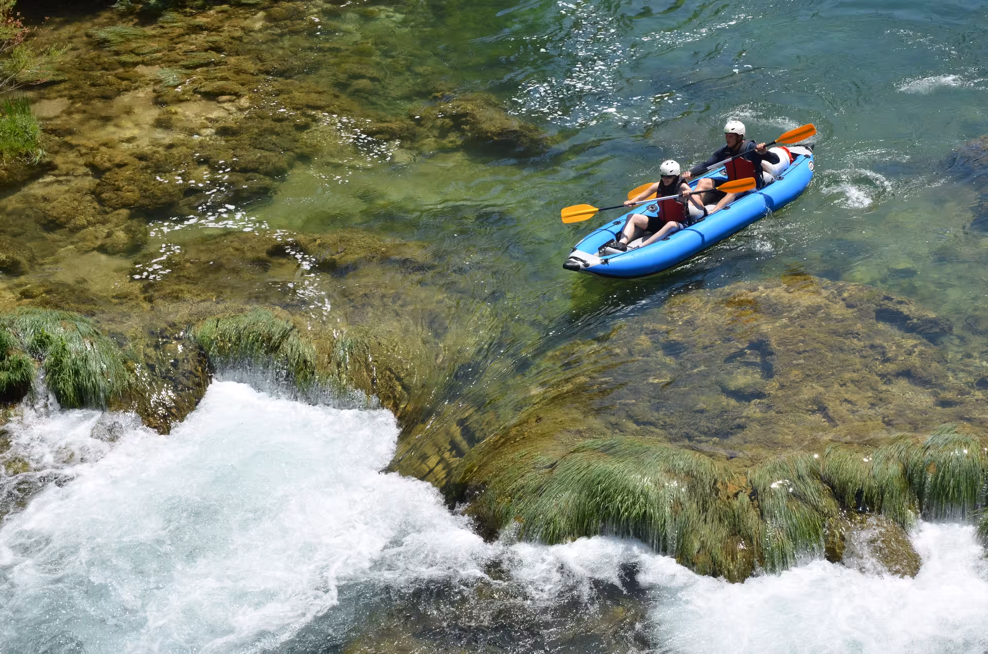 Adventurous duo paddling through pristine waters on a Zrmanja Canoe Safari, showcasing lush surroundings and excitement.