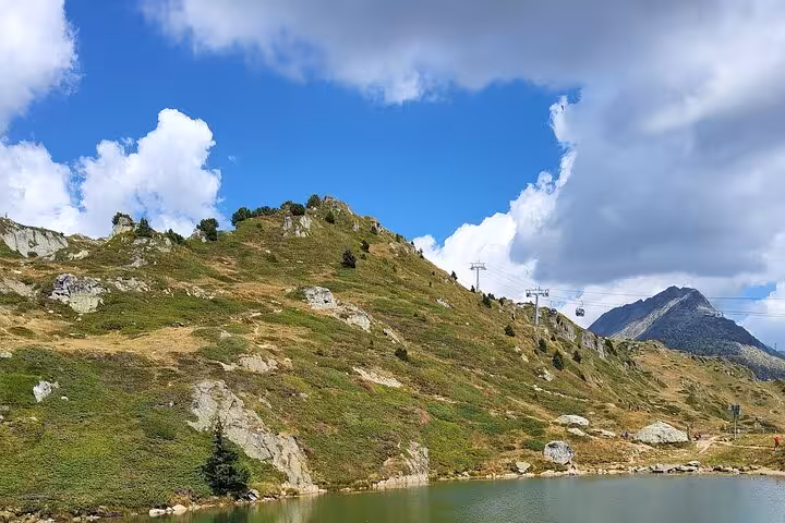 Scenic alpine lake and hillside near Aletsch region on Zurich day trip, with cable car and peaks