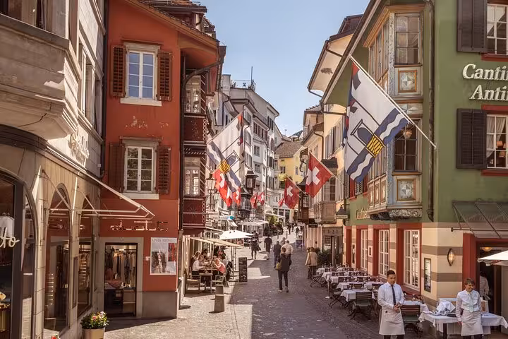 Niederdorf Old Town street with Swiss flags and cafes on Zurich 360 city walk hidden spots tour