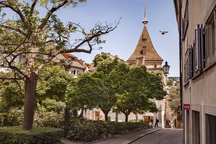 Quiet Zurich Old Town lane with leafy park and historic tower, 360 city walk tour hidden spots