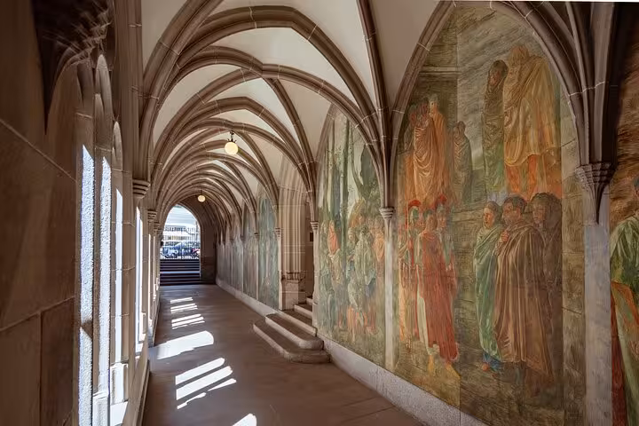 Historic arched cloister with fresco murals in Zurich Old Town, featured on Zurich 360 city walk tour