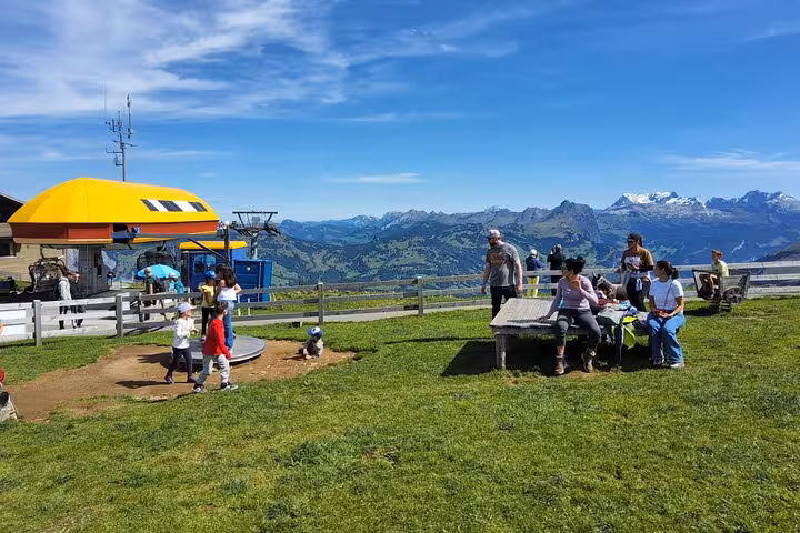 Kids play near Mount Rigi cable car station on Zurich day trip, with sweeping Swiss Alps mountain views