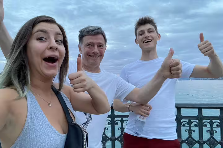 Happy group giving thumbs up by Lake Zurich on a Zurich scavenger hunt and sights self-guided tour