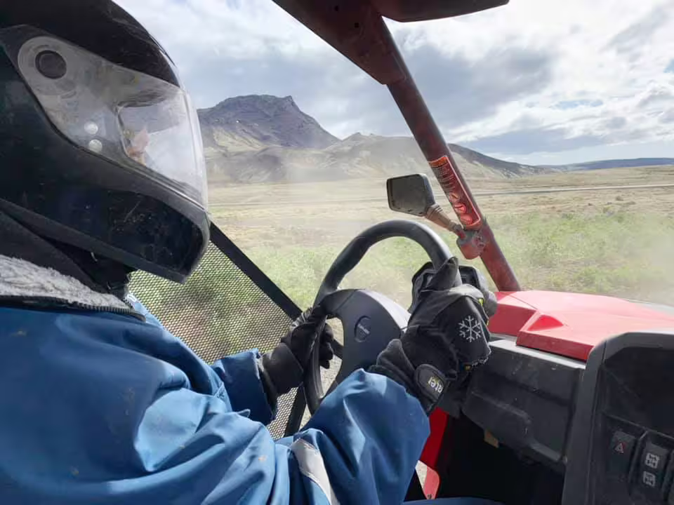 Person driving a buggy on a thrilling 2-hour lava field adventure, showcasing rugged terrain and scenic volcanic landscapes.