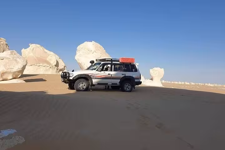 4x4 jeep in Egypt’s White Desert near chalk rock formations on a 2-day private White & Black Desert tour
