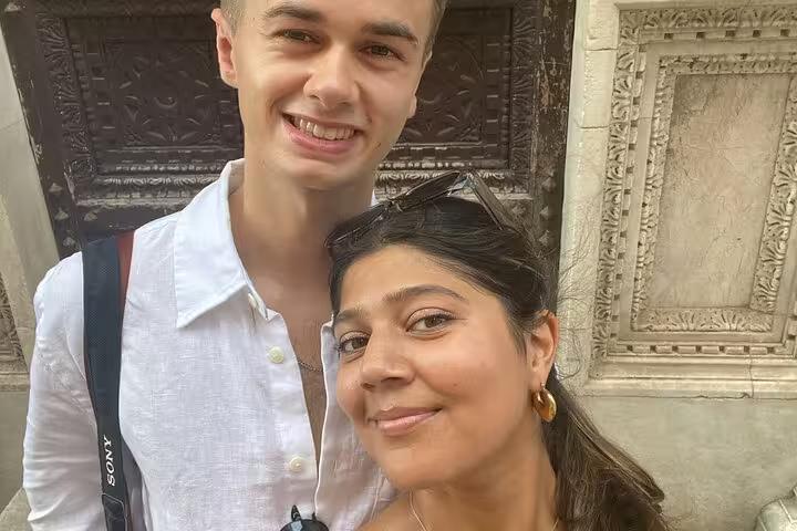 Smiling couple posing at a historic Pisa landmark during a self-guided mystery puzzle adventure tour
