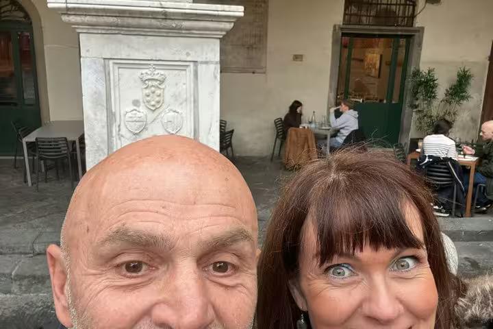 Couple posing at historic Pisa piazza marble monument during fun self-guided mystery puzzle walking tour