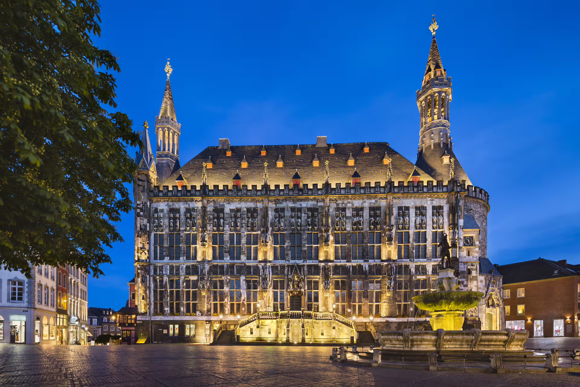 Illuminated Aachen Town Hall on Markt Square at dusk, key stop on Aachen in 1 day walking tour audioguide