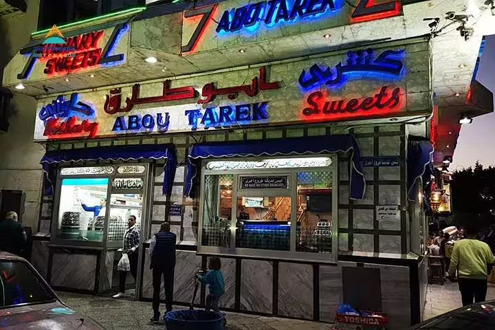 Abou Tarek koshary restaurant facade lit at night in Downtown Cairo, featured on the half-day tour with dinner